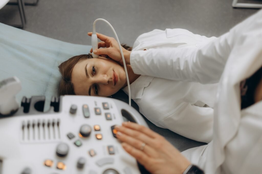 Doctor using ultrasound scanning machine for examining a head of woman